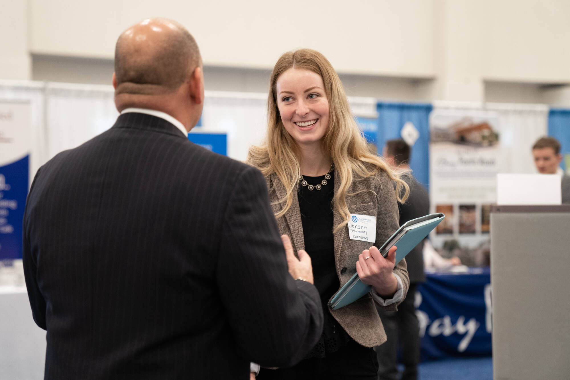 Student networking at a career fair with a business professional